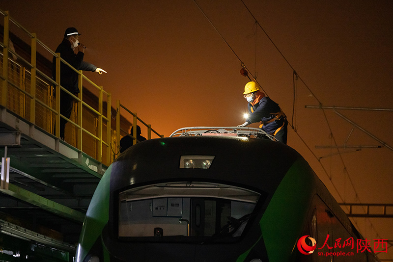 1月26日，西安客車(chē)車(chē)輛段，鐵路檢修“小哥”們正在檢查動(dòng)力集中型動(dòng)車(chē)組車(chē)頂高壓電器。劉翔攝