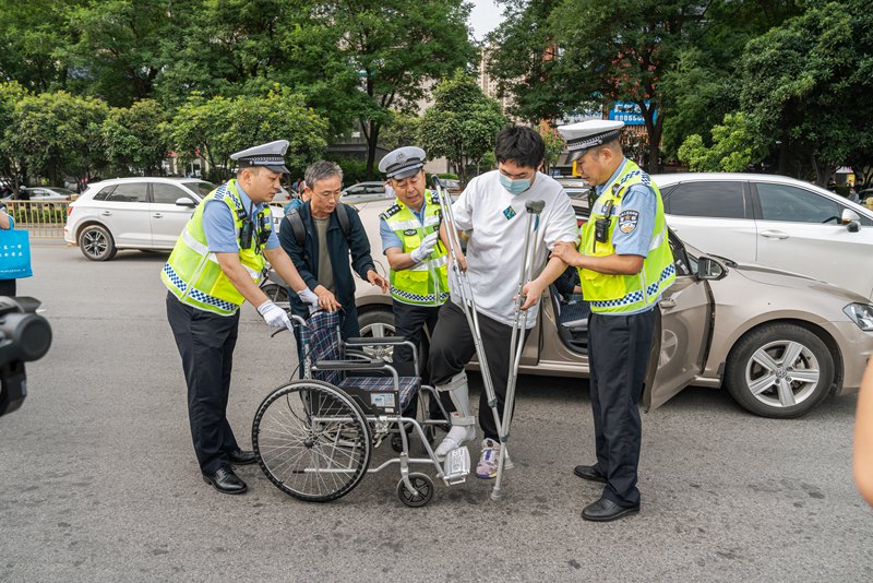 考生坐輪椅赴考，西安交警合力護(hù)送。孫崇明 攝