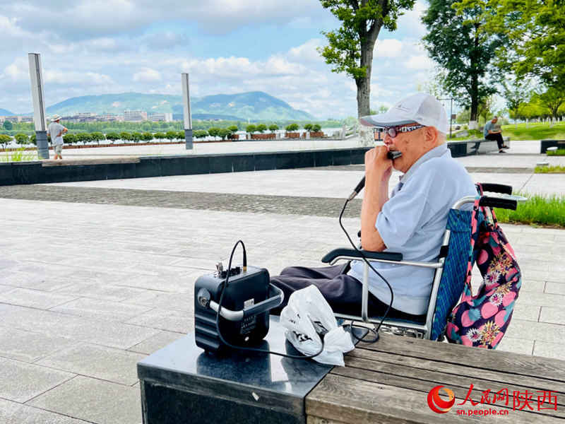 94歲的張大爺每天都會到天漢濕地公園憩息吹口琴。人民網(wǎng)記者 孫挺攝