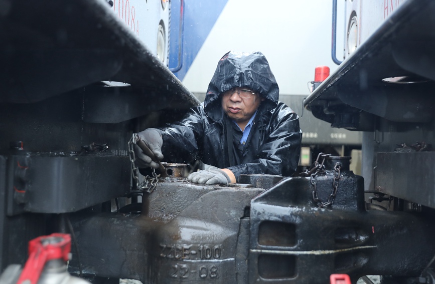 安康機務段庫內，調車員在雨中進行機車連掛作業(yè)。劉衛(wèi)東攝