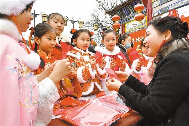 1月20日，西安永興坊·陜西非遺文化特色街區(qū)內(nèi)，非遺傳承人給孩子們教授剪紙、捏面人等非遺技藝。杜瑋攝